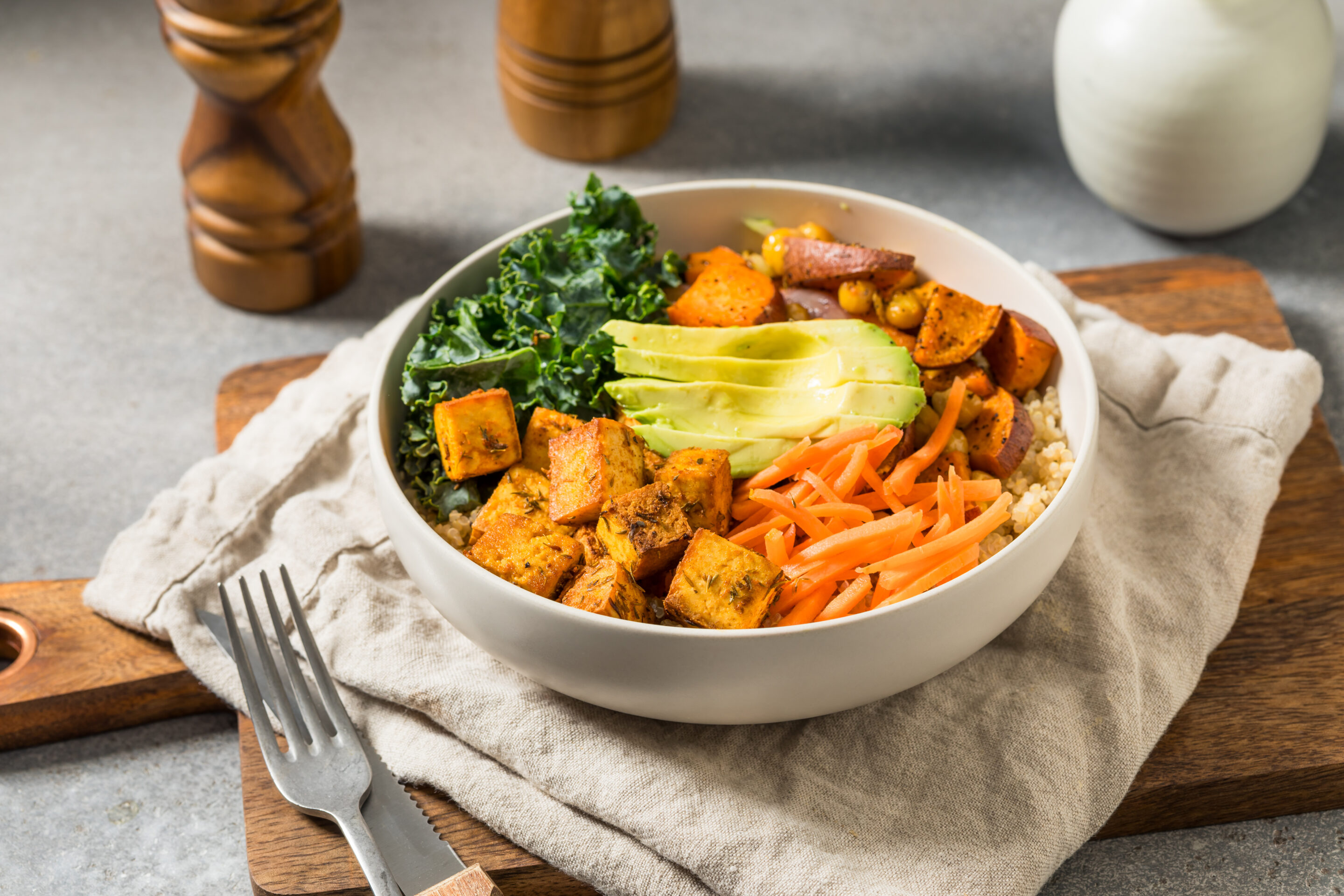 Schale mit Buddha Bowl. Gabel. Leinentuch und Pfeffer und Salz