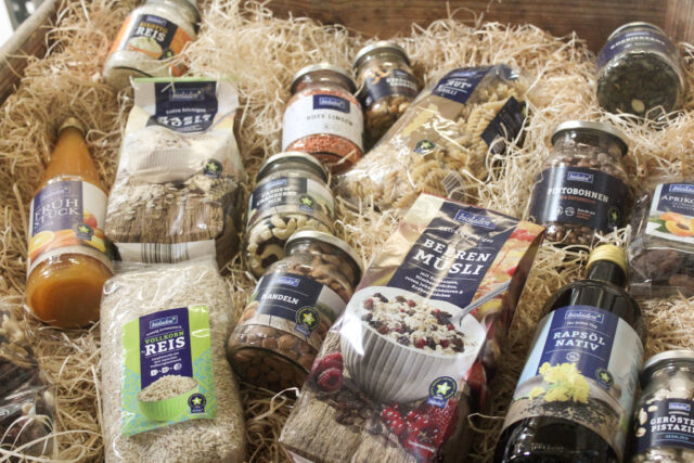 Verschiedene Bioladen Produkte positioniert auf Holzwolle